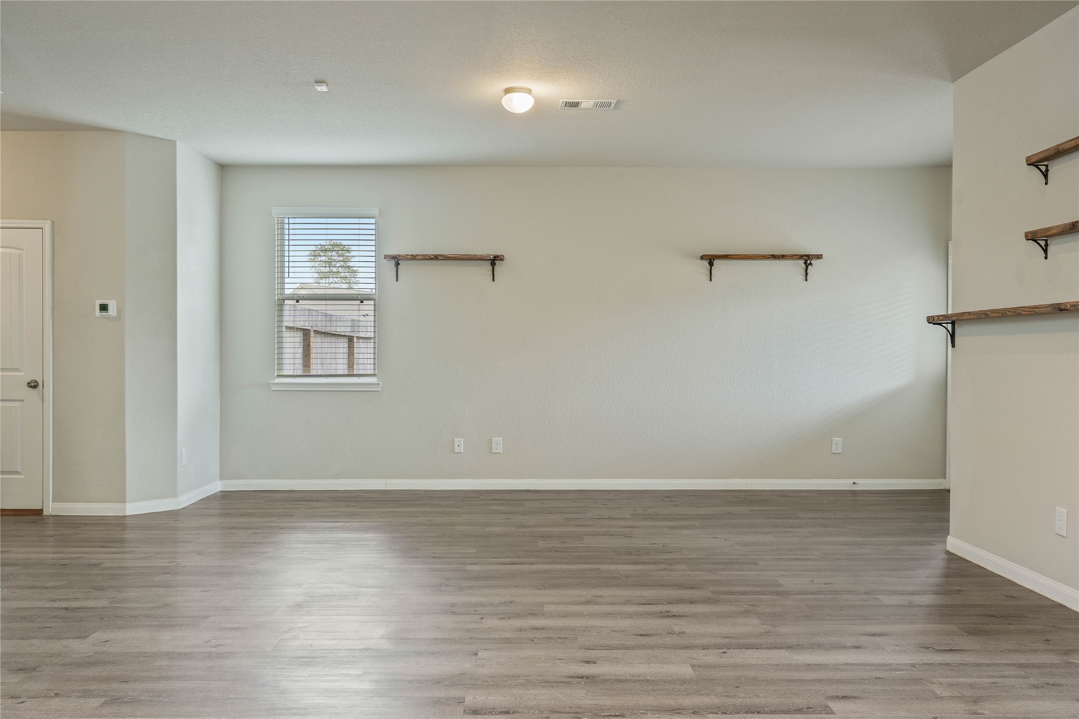 2205 Angie Kaye Drive Conroe, TX 77301 - Photo 11 of 46 a view of an empty room with wooden floor and a window