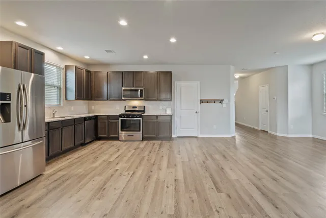 a kitchen with stainless steel appliances a refrigerator and a stove top oven