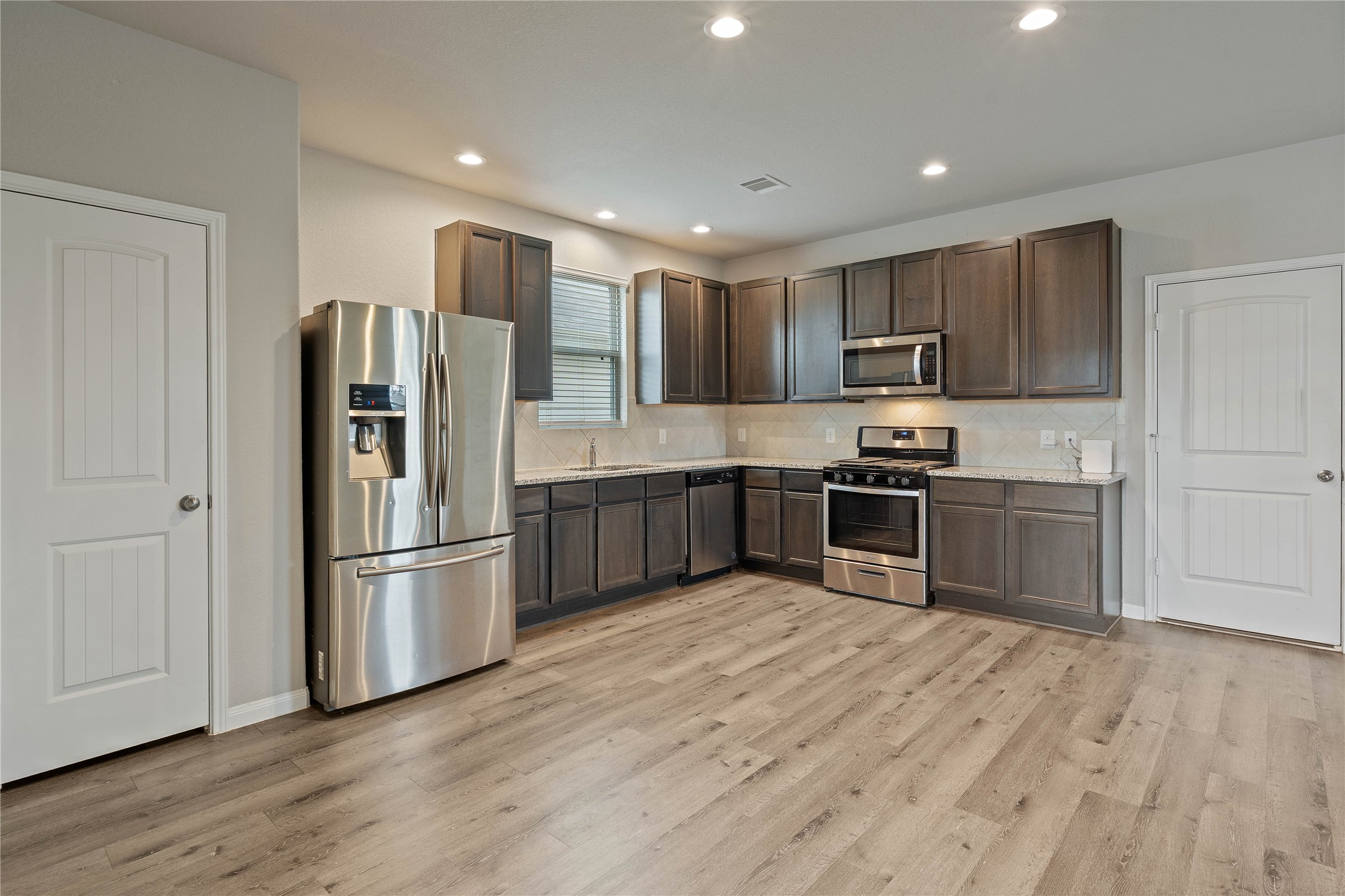 2205 Angie Kaye Drive Conroe, TX 77301 - Photo 17 of 46 a kitchen with stainless steel appliances a refrigerator and a stove top oven