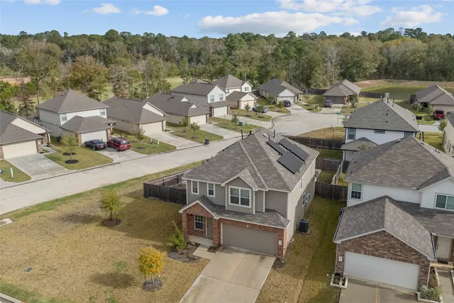 an aerial view of a house with a mountain