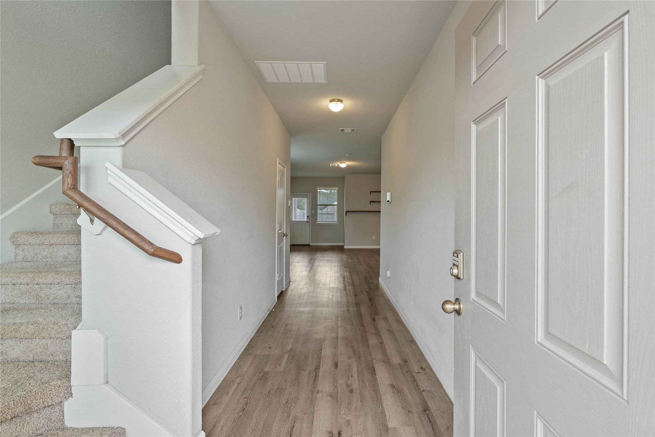 2205 Angie Kaye Drive Conroe, TX 77301 - Photo 6 of 46 a view of a hallway with wooden floor and staircase