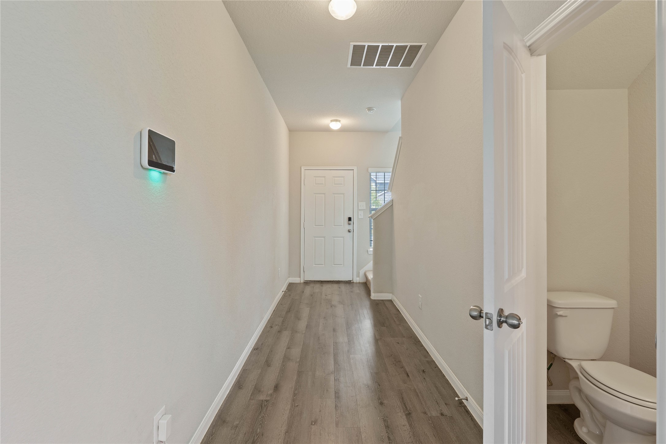 2205 Angie Kaye Drive Conroe, TX 77301 - Photo 7 of 46 a view of a hallway with wooden floor and a bathroom