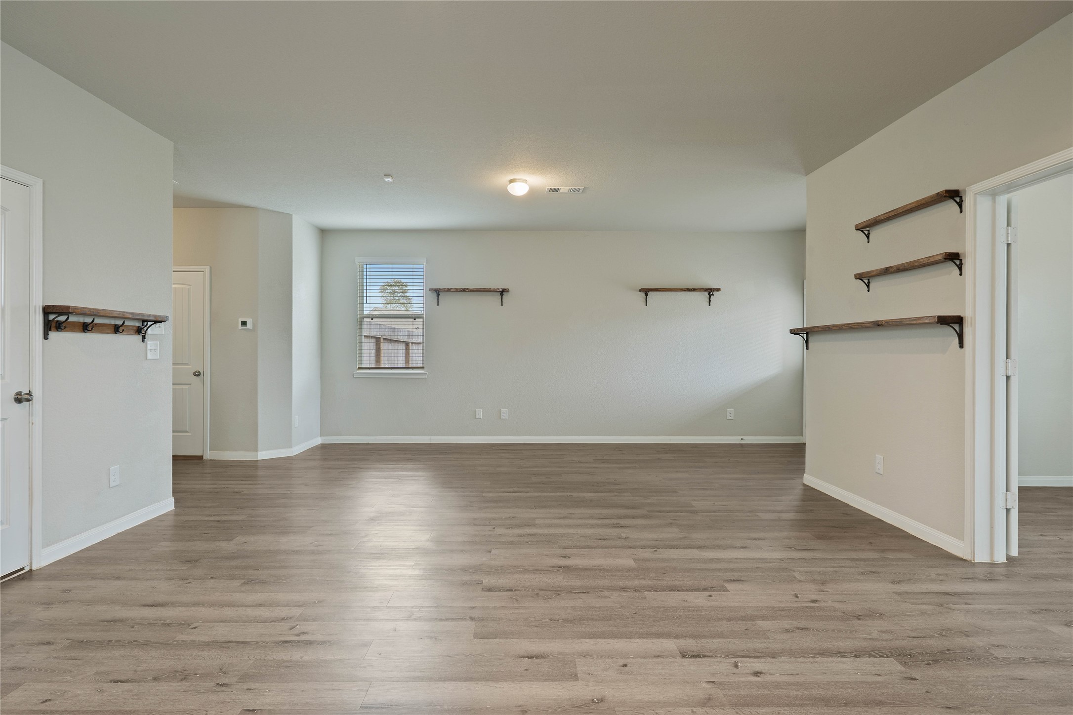 2205 Angie Kaye Drive Conroe, TX 77301 - Photo 9 of 46 a view of an empty room with wooden floor and a refrigerator