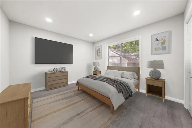 a spacious bedroom with a bed and a flat screen tv