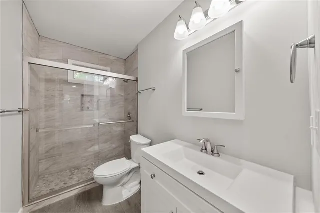 a bathroom with a sink mirror toilet and shower