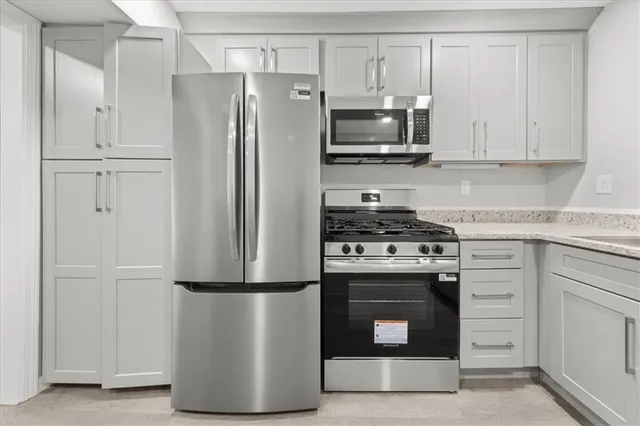 a kitchen with white cabinets and stainless steel appliances