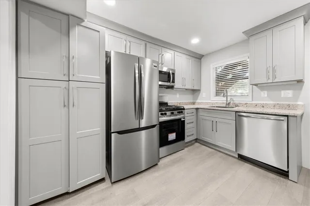 a kitchen with a refrigerator a sink and cabinets