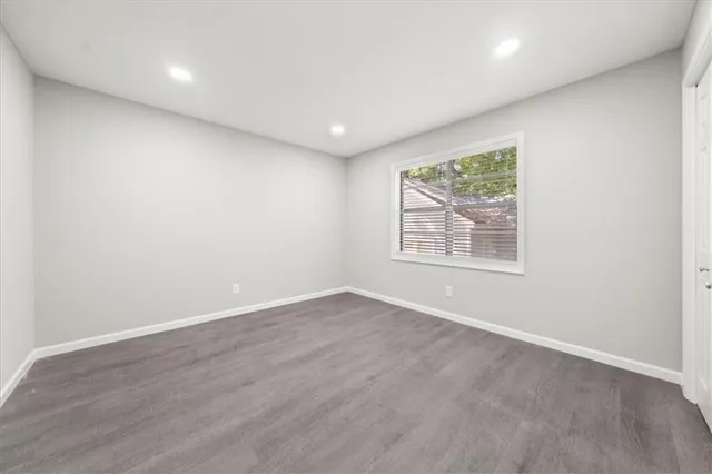 an empty room with wooden floor and window