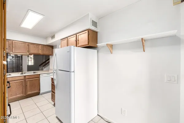 a white refrigerator freezer and a stove sitting inside of a kitchen