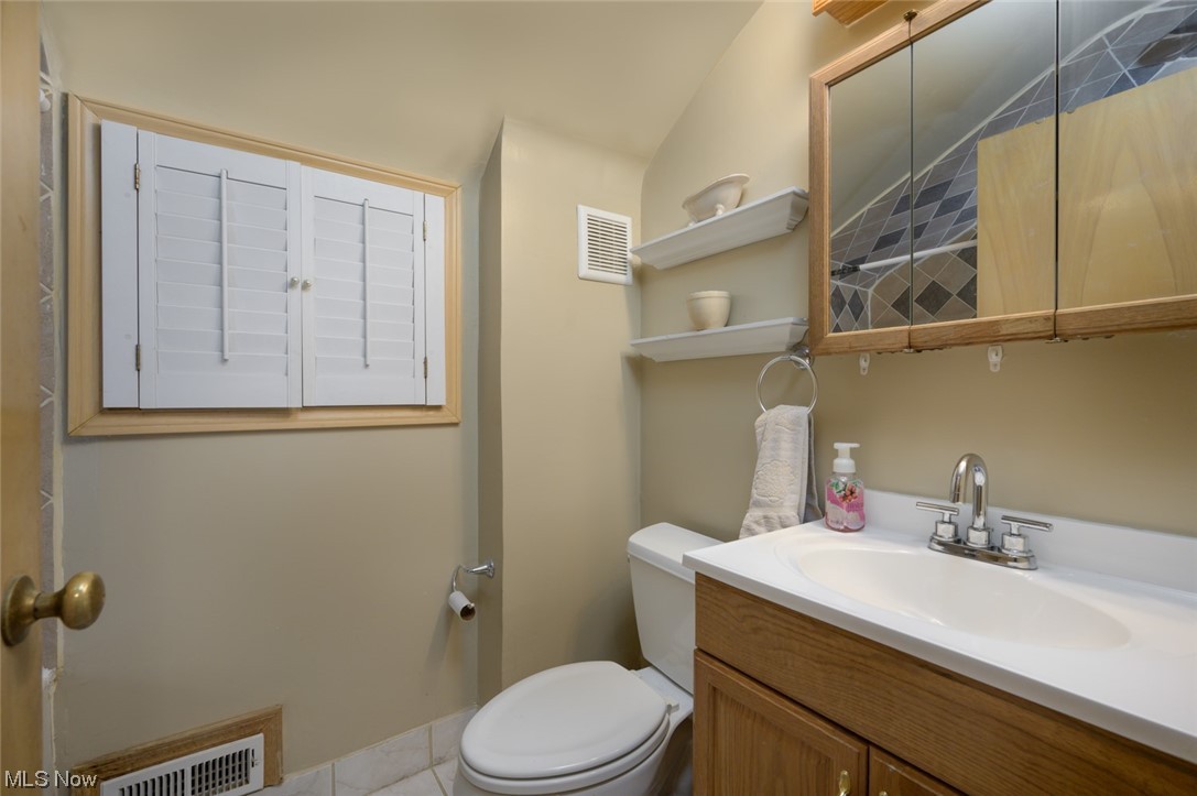 6132 North Canterbury Road Parma, OH 44129 - Photo 30 of 34 Bathroom with ceramic tile flooring, vanity with extensive cabinet space, and toilet