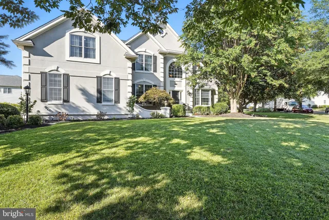 a front view of a house with a yard and trees