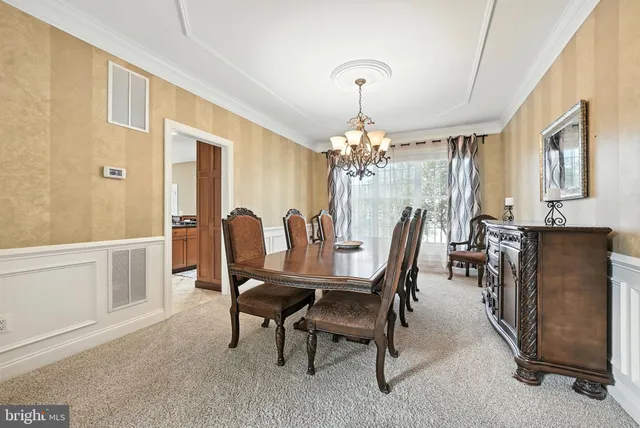 a view of a dining room with furniture and chandelier