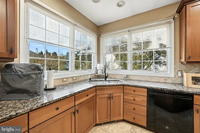 a kitchen with stainless steel appliances kitchen island granite countertop a refrigerator a stove and a sink