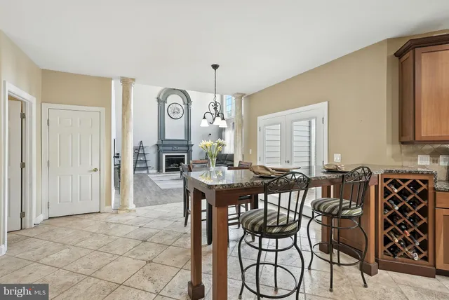 a kitchen with stainless steel appliances granite countertop a dining table chairs and granite counter tops