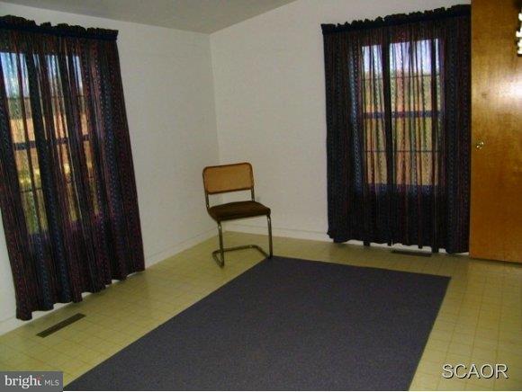 3922 Fox Hunters Road, Unit 1 Harrington, DE 19952 - Photo 11 of 16 a room with a window and a chair