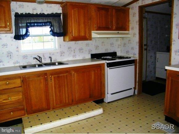 3922 Fox Hunters Road, Unit 1 Harrington, DE 19952 - Photo 3 of 16 a kitchen with granite countertop a sink stove and cabinets