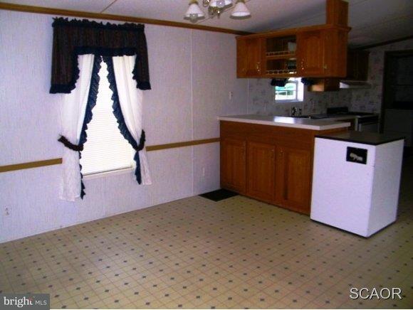 3922 Fox Hunters Road, Unit 1 Harrington, DE 19952 - Photo 4 of 16 a kitchen with kitchen island granite countertop cabinets a sink a window and stainless steel appliances