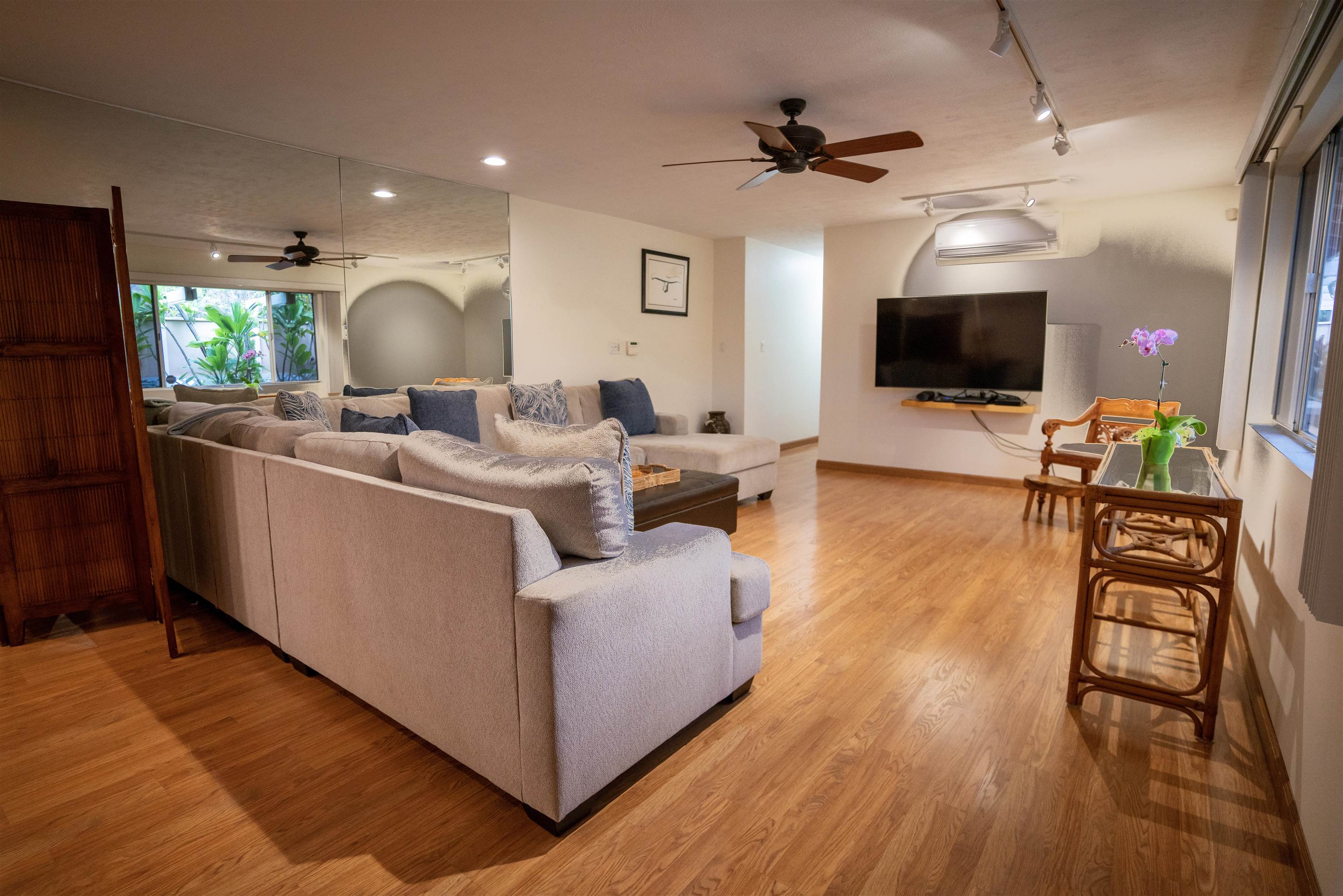 107 Mehani Place Kihei, HI 96753 - Photo 3 of 30 a living room with furniture a flat screen tv and a wooden floor