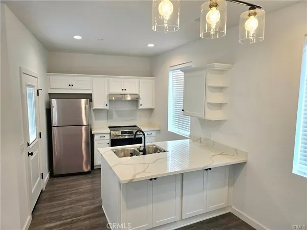 a kitchen with white cabinets and stainless steel appliances