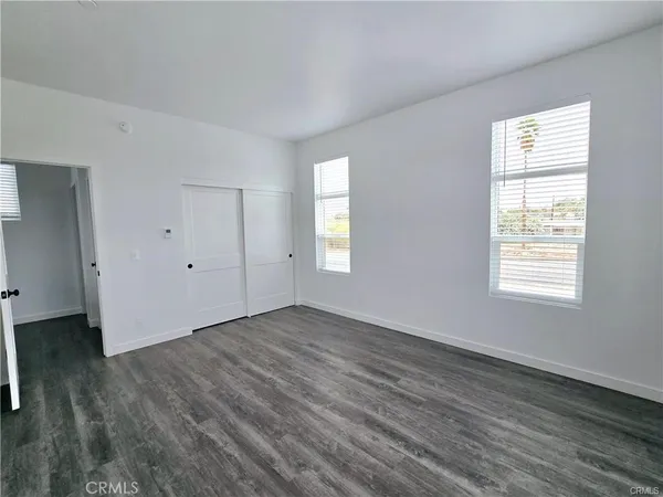 an empty room with wooden floor and window