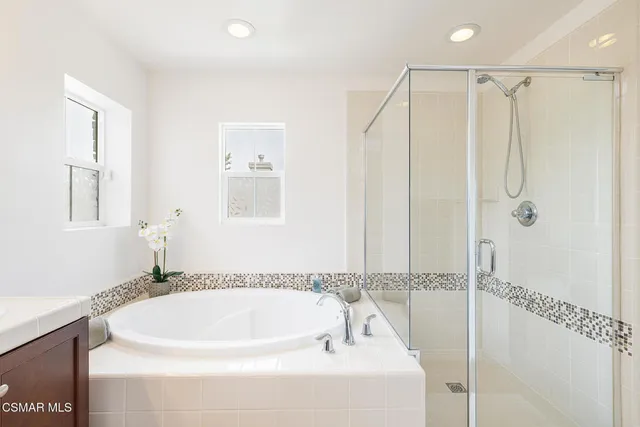 a white bath tub sitting next to a shower