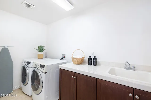 a utility room with sink dryer and washer