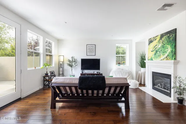 a living room with furniture a fireplace and a large window