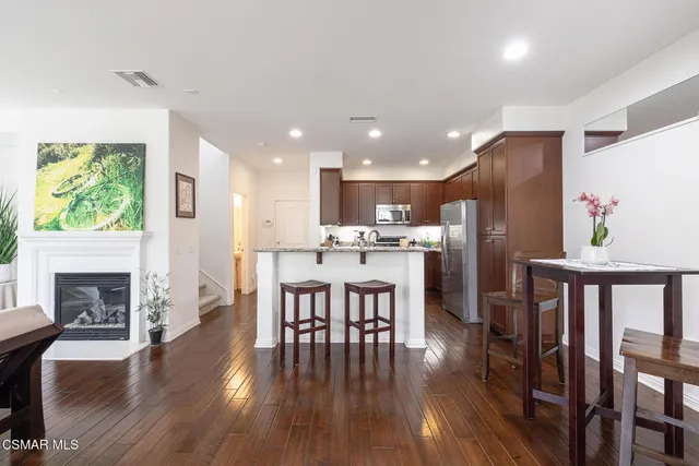 a dining room with furniture a fireplace and wooden floor