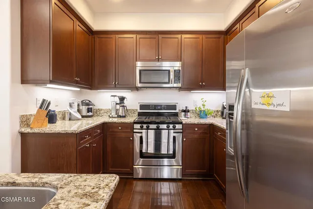 a kitchen with stainless steel appliances granite countertop a refrigerator stove and sink