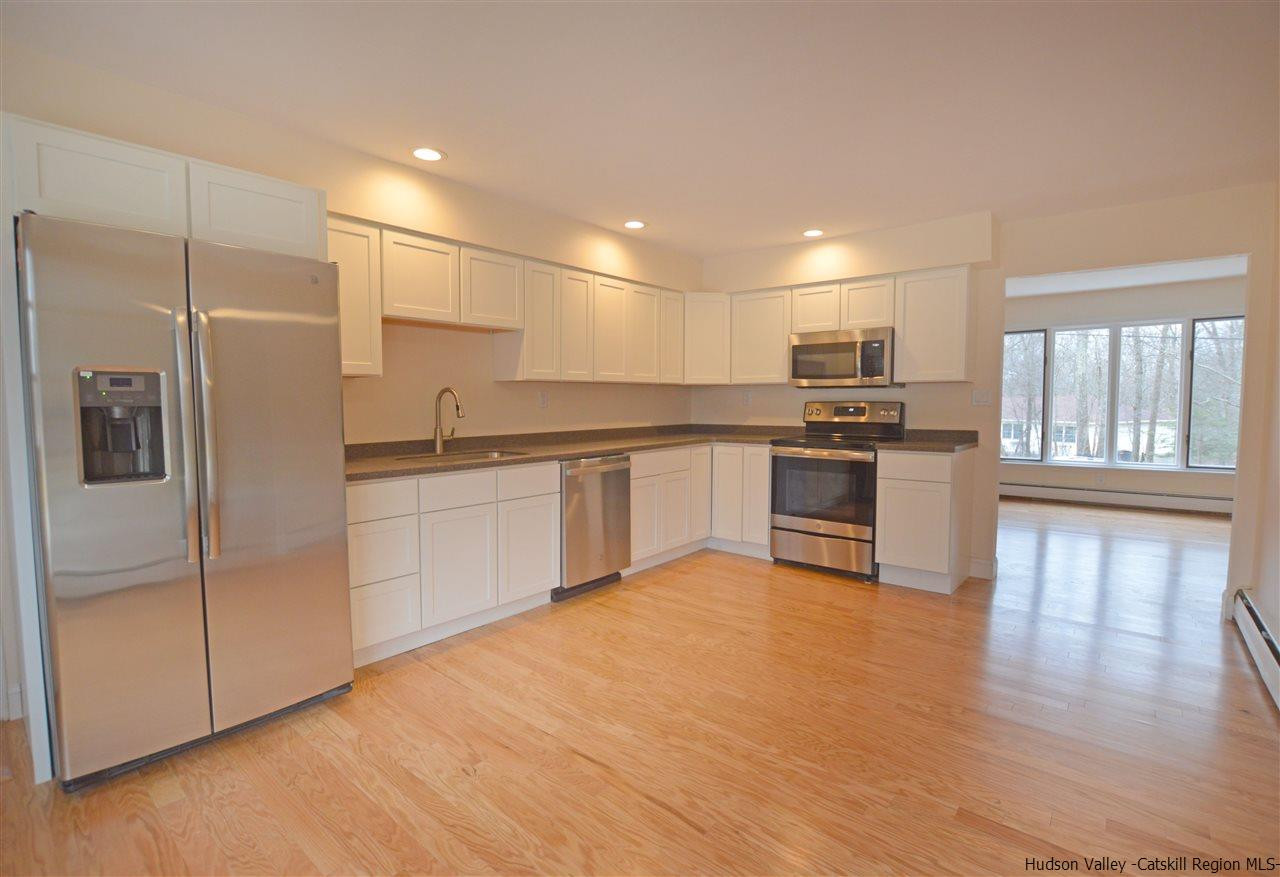 47 Roxanne Boulevard Highland, NY 12528 - Photo 5 of 24 a kitchen with stainless steel appliances granite countertop a refrigerator a sink a stove and white cabinets with wooden floor