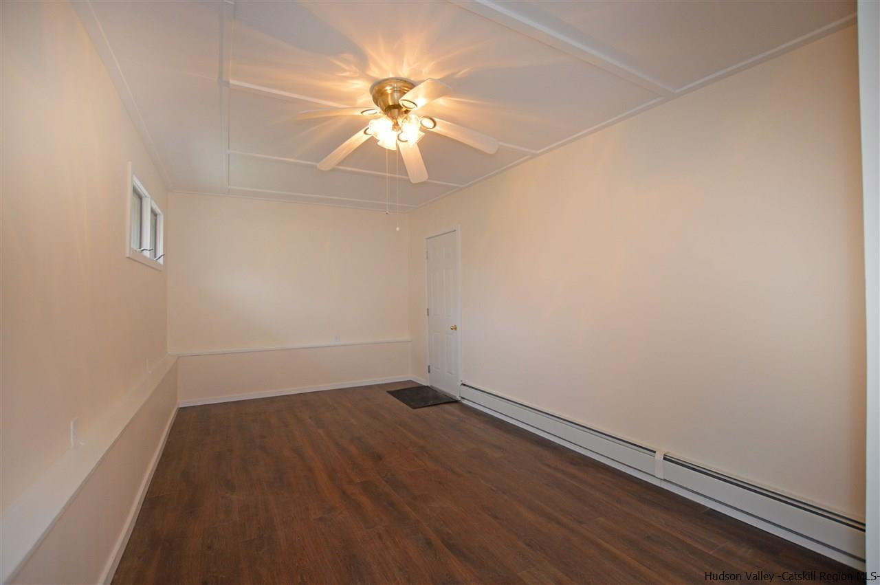 47 Roxanne Boulevard Highland, NY 12528 - Photo 9 of 24 an empty room with a chandelier fan and wooden floor