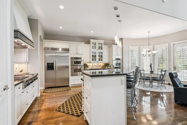 a kitchen with stainless steel appliances kitchen island granite countertop a refrigerator and stove