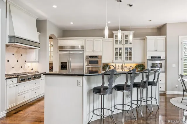 a kitchen with stainless steel appliances kitchen island granite countertop a table and chairs in it