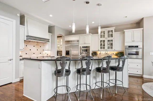 a kitchen with stainless steel appliances kitchen island granite countertop a refrigerator and cabinets