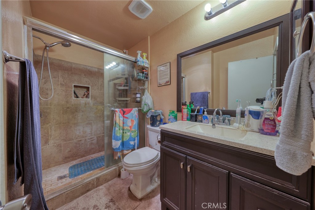 1800 East Old Ranch Road, Unit 148 Colton, CA 92324 - Photo 22 of 23 a bathroom with a sink a toilet and shower