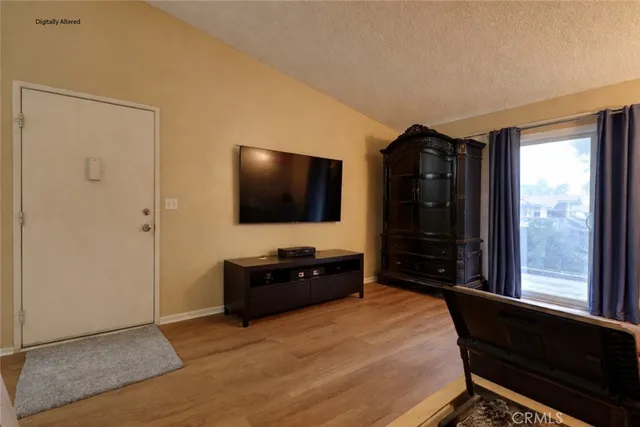 a bedroom with a bed and a flat tv screen on dresser