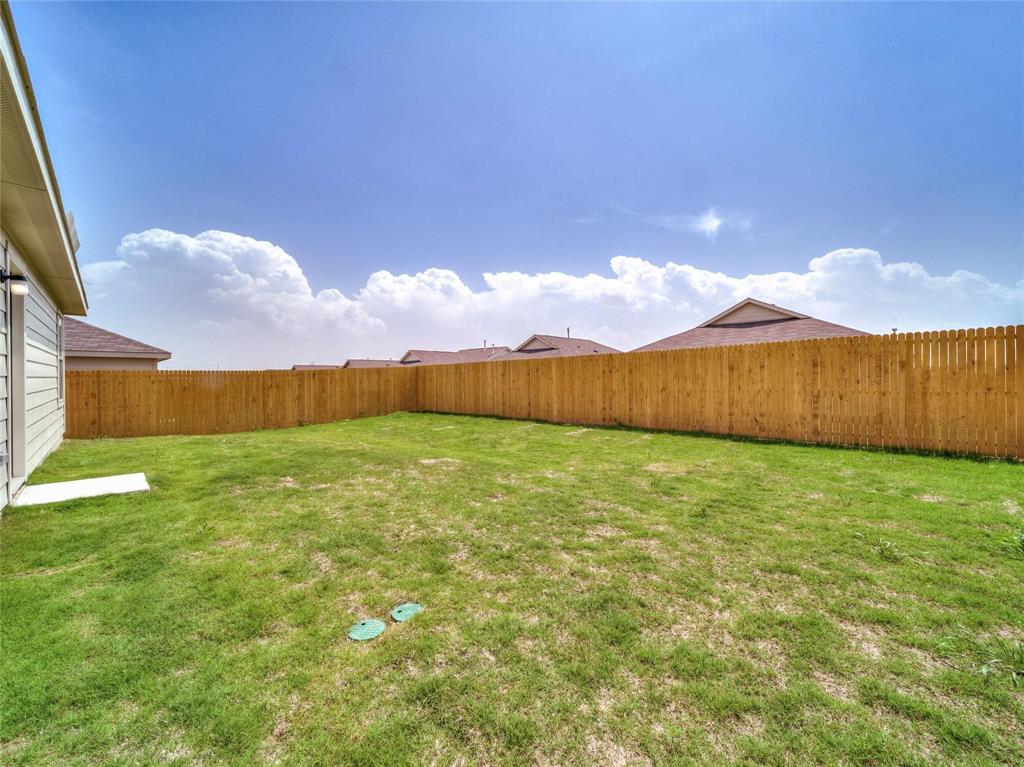 357 Sun Bluff Road Fort Worth, TX 76052 - Photo 22 of 35 Expansive grassy yard featuring a new privacy fence, visible siding, and a clear sky