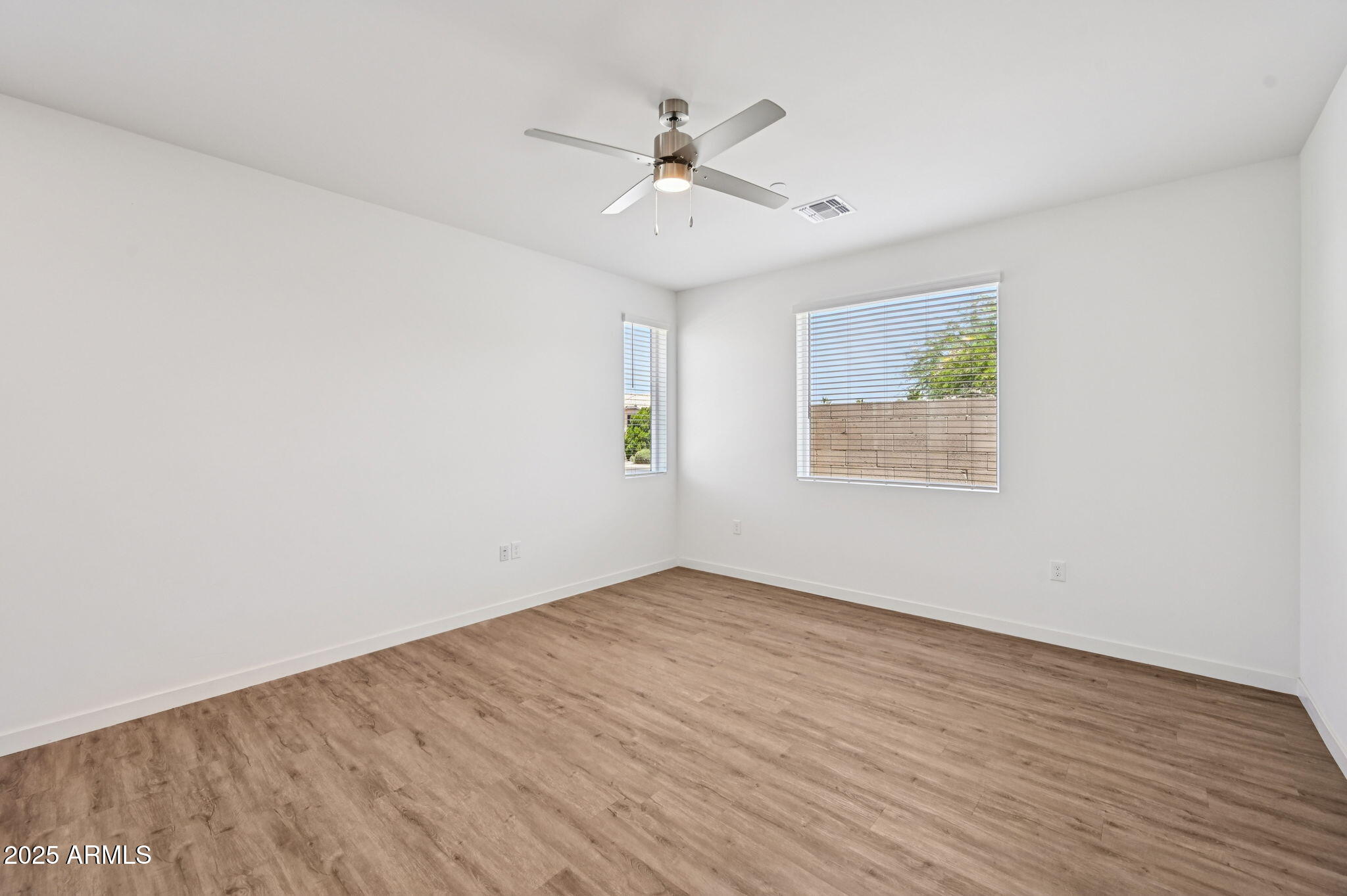 2131 East Jennifer Lynn Way Phoenix, AZ 85022 - Photo 14 of 45 an empty room with wooden floor ceiling fan and windows