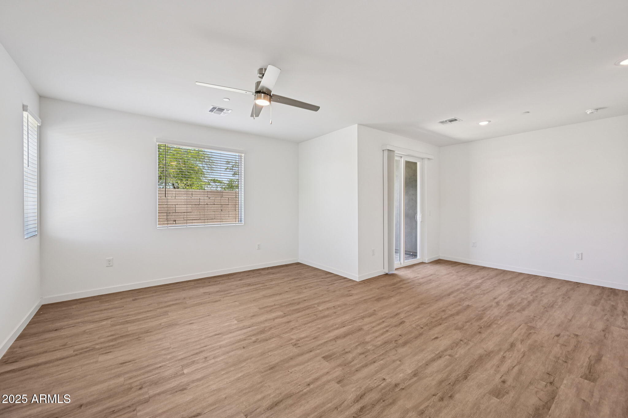 2131 East Jennifer Lynn Way Phoenix, AZ 85022 - Photo 16 of 45 an empty room with wooden floor ceiling fan and windows