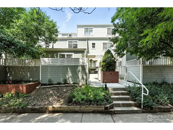 a view of swimming pool with seating area and trees in the background