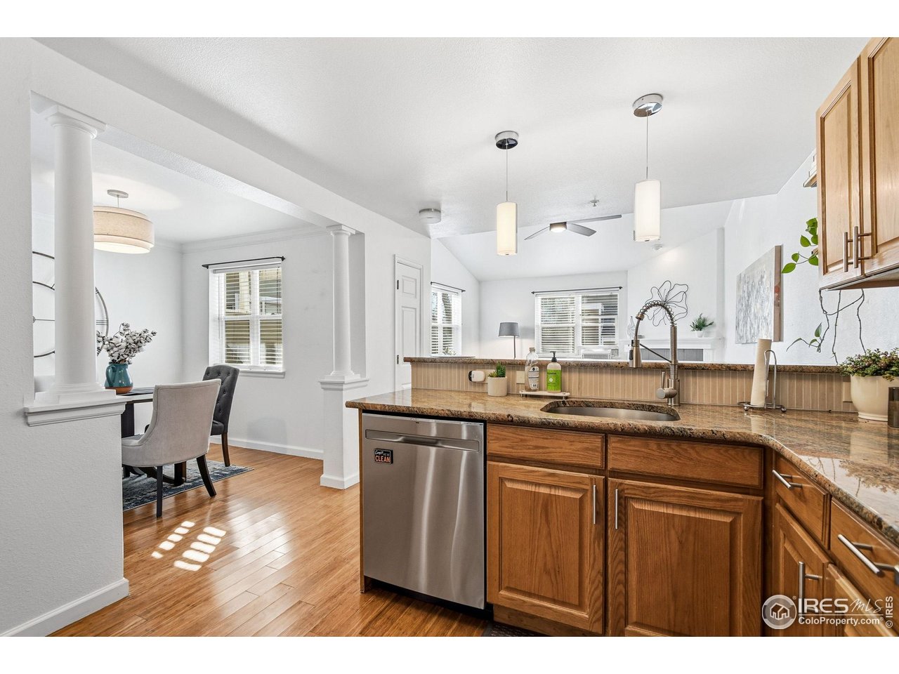 3077 29th Street, Unit 105 Boulder, CO 80301 - Photo 6 of 27 a kitchen with kitchen island granite countertop a sink cabinets and wooden floor