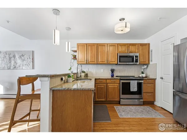 a kitchen with kitchen island a stove top oven a sink a dining table and chairs