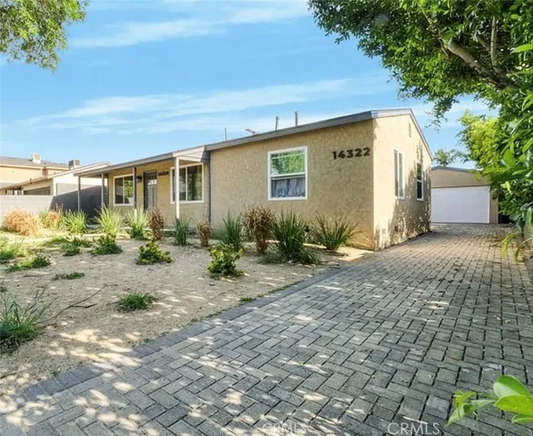 a backyard of a house with potted plants and large tree