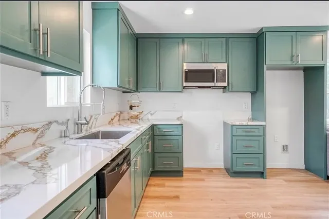 a living room with stainless steel appliances kitchen island granite countertop furniture and a large window