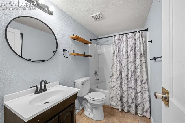 a view of a house with a small yard plants and large tree