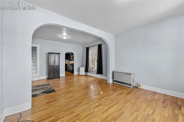 a view of empty room with wooden floor