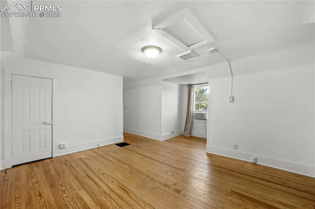 a view of empty room with wooden floor