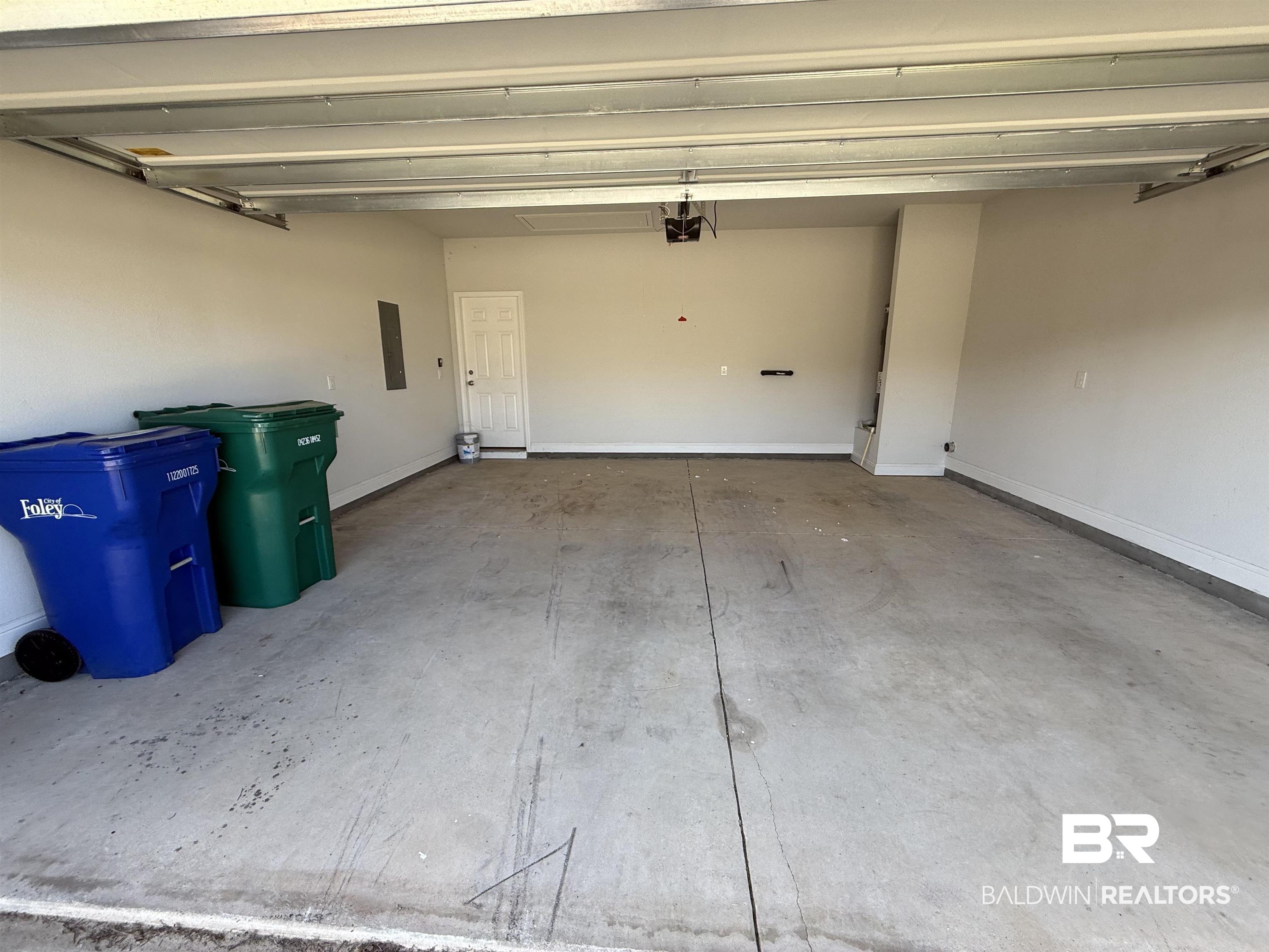 23247 Lieutenant Avenue Foley, AL 36535 - Photo 46 of 47 Attached garage with a concrete floor, painted walls, and an overhead garage door mechanism
