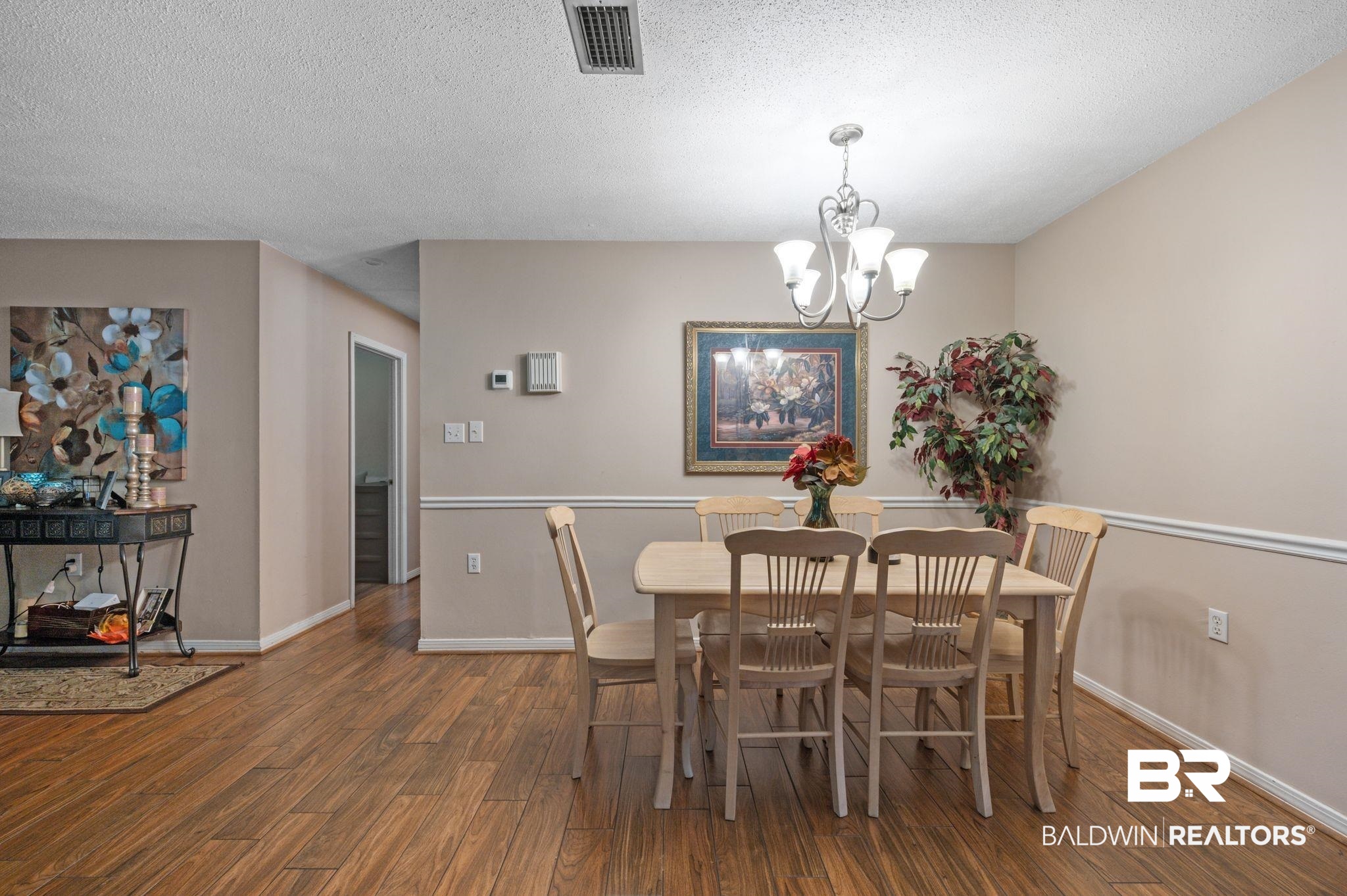 4566 McCrary Road, Unit A Semmes, AL 36575 - Photo 13 of 28 Dining area featuring dark wood-type flooring, a textured ceiling, and a notable chandelier