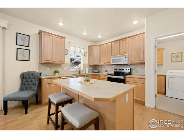 a kitchen with a refrigerator a stove a sink dishwasher with a dining table and chairs